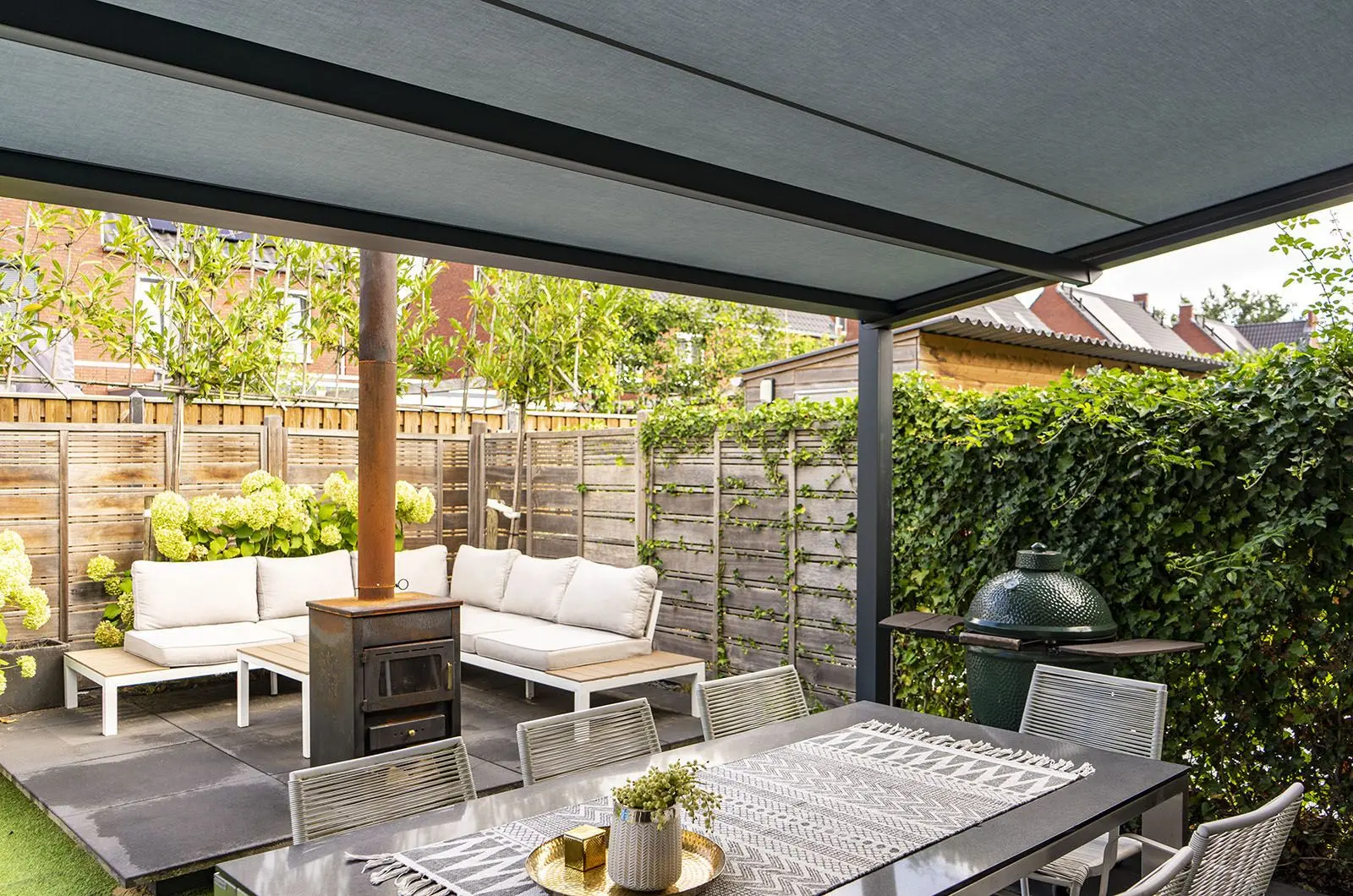 Pergolazonwering met glazen wanden boven een terras